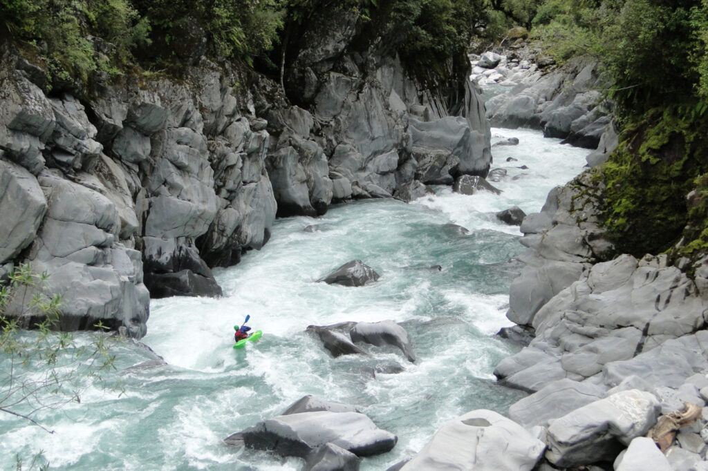 A kayaker paddling the Waitaha River. Photo Credit: Andy England